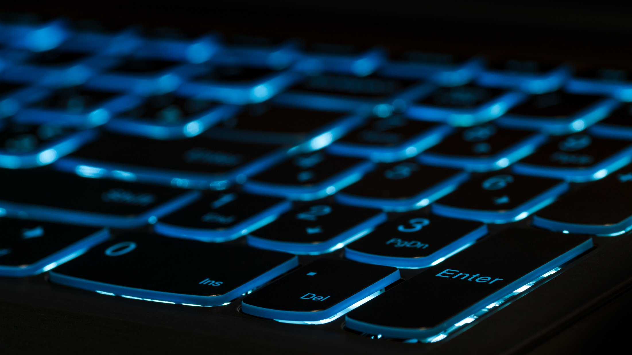 Enter key. Blue backlight, backlit on gaming laptops computer in the dark.